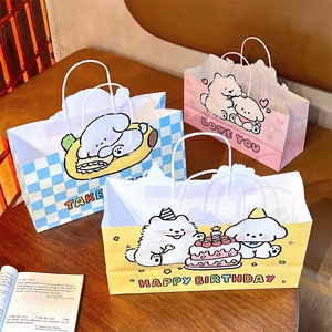 Detailed view of three cute cartoon puppy paper gift bags on a wooden table setup