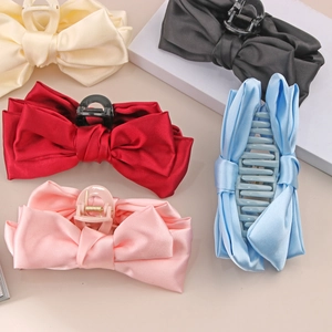 Detail of satin bow claw clips in cream, black, red, pink, and sky blue fabrics