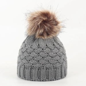 Close-up of grey knit baby beanie with textured pattern and fluffy brown faux fur pompom