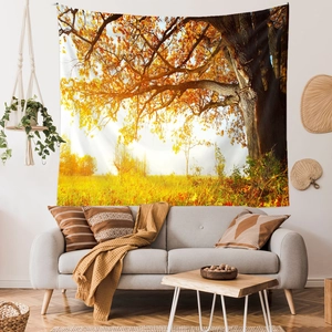 Detailed view of large golden forest wall tapestry hanging above a modern sofa