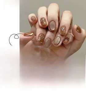 Detailed view of mocha and caramel short press-on nails with gold foil and 3D floral accents