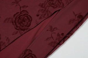 Close-up of dark red rose pattern on textile fabric for an elegant summer dress