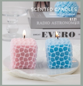 Macro shot of lit pink and blue honeycomb geometric scented candles for home decor