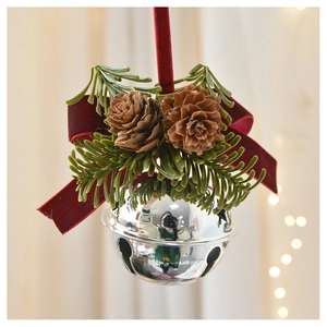 Detail of Christmas bell ornament with red velvet bow, pine cones and green needles