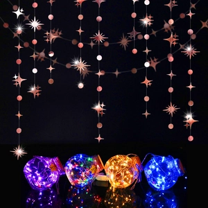Vista macro di ghirlande a stella in oro rosa appese su barattoli con luci a LED