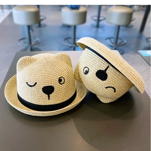 Detailed texture of straw woven sun hat with cute bear ears and embroidered facial features