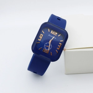 Detail view of square blue quartz watch with silicone strap and gold numerals showing weekday dial