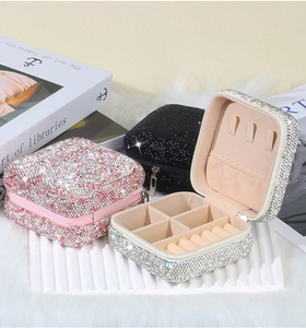 Detail of portable rhinestone jewelry cases in pink, black, and silver with velvet lining