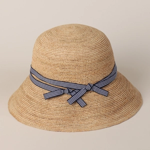 Classic straw sun hat with blue and white striped bow for summer beach travel