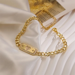 Detailed view of golden Cuban link bracelet with a pavé rhinestone heart charm on satin
