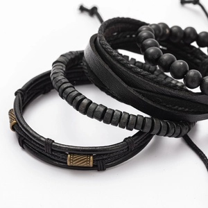Detail of multi-layer leather bracelets with wooden beads and metal clasp on white background