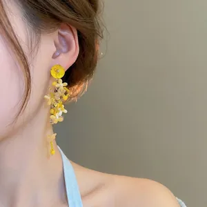 Vibrant yellow floral tassel earrings with handmade resin flowers and beaded clusters