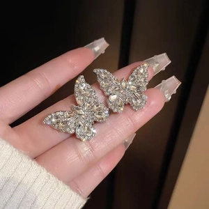 Macro shot of silver butterfly earrings with sparkling cubic zirconia on a dark background