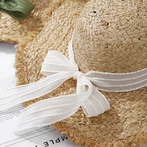 Raffia sun hat with fringe edge and white chiffon ribbon for summer beach vacation