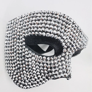 Macro shot of black half-face mask with sparkling silver rhinestones for parties