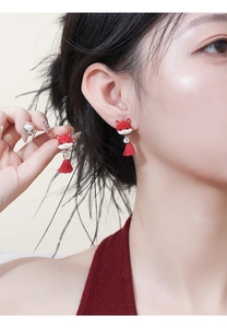 Detail of red Chinese zodiac horse earrings with tassels worn by model for festive style