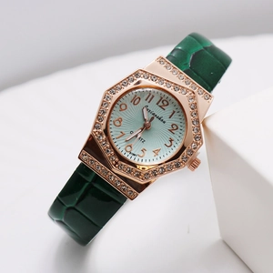 Macro view of rose gold octagonal watch case with diamonds and green leather strap