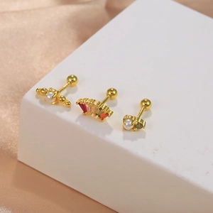Macro shot of gold S925 silver stud earrings with pearls and colored zircons on silk