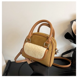 Detail of brown suede tote bag with cream plush trim and silver hardware accents