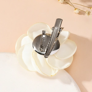Detail of cream fabric rose corsage with metal brooch pin and hair clip dual back