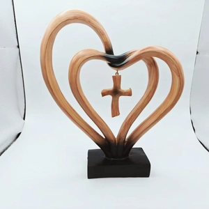 Detailed view of intertwined wooden hearts with a hanging cross on a black stand