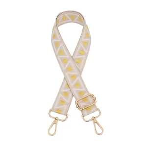 Close-up of geometric woven shoulder strap with gold metal hooks and adjustable buckle