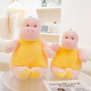 Close-up of soft pink and yellow dinosaur plush toys on a stylish round coffee table