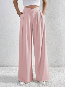 Detail shot of pink wide-leg trousers featuring a V-shaped high waistband and pleated fabric