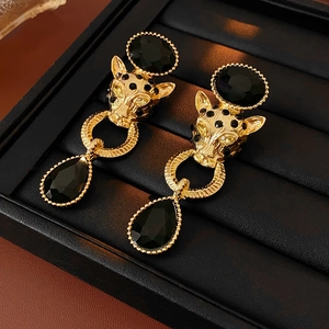 Macro detail of gold vintage panther earrings with black gemstones in jewelry box