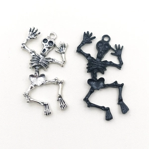Detailed view of silver and black dancing skeleton pendants for DIY jewelry making