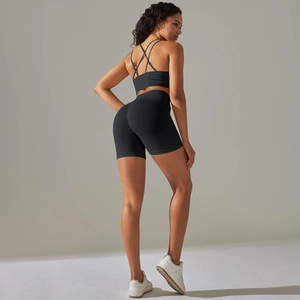 Detail der gekreuzten Träger am schwarzen Yoga-Bra und den High-Waist-Shorts im Set