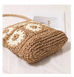 Close-up of the reinforced bottom of this handmade straw beach bag with daisy patterns