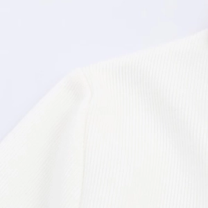 Macro shot of white ribbed knit fabric showing detailed stitching and soft texture