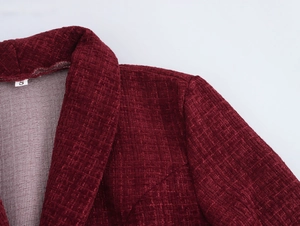 Nahaufnahme des weinroten Tweed-Kleides mit Webstruktur und V-Ausschnitt-Detail