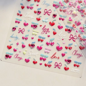 Detail of 3D cherry and heart nail art stickers with glossy sweet lettering patterns