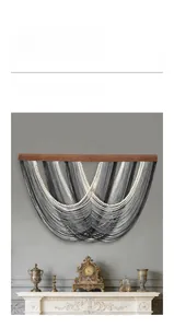 Détail d'une tenture bohème avec pompons gris dégradés et perles en bois naturel
