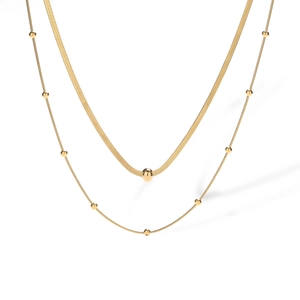 Detail of layered gold double strand necklace with snake chain and polished beads