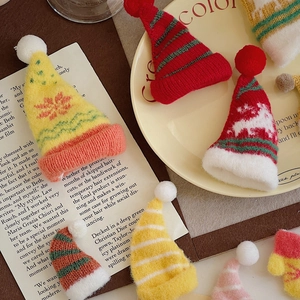 Detailed view of assorted miniature knitted Christmas hats with pom-poms for DIY crafts