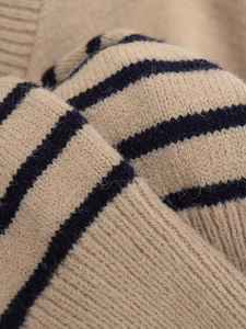 Detailed macro shot of high-quality striped knit sweater fabric with ribbed cuffs
