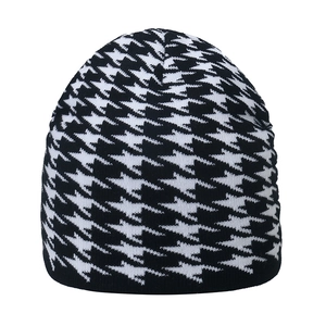 Close-up of knitted houndstooth beanie showing detailed black and white stitch texture
