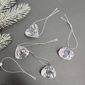 Detail of transparent acrylic diamond-shaped ornaments with silver hanging strings