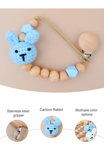 Detailed view of handmade crochet rabbit and wooden beads on a blue baby pacifier clip