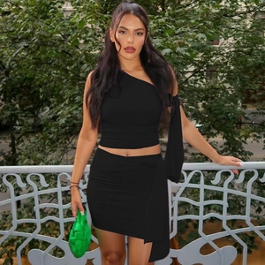 Detail of black off-shoulder long sleeve top and matching mini skirt on model outdoors