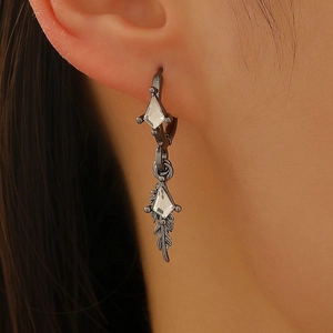 Detail of gunmetal feather earrings with a geometric rhinestone stud on a model