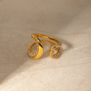 Macro detail of gold open ring featuring twisted band and inlaid cubic zirconia stones