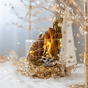 Christmas centerpiece with pine cones and LED glass jar on a snowy backdrop