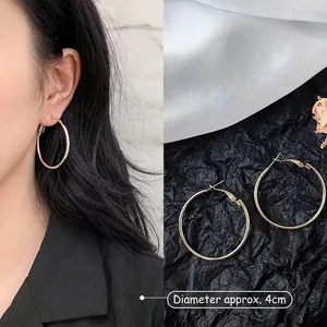 Detailed view of 4cm gold hoop earrings with model display and high-shine metallic finish