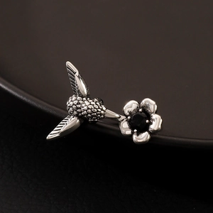 Macro shot of silver hummingbird ring with engraved wings and black gemstone detail