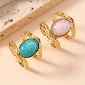 Detail of vintage double-line gold rings with turquoise and pink oval natural stones