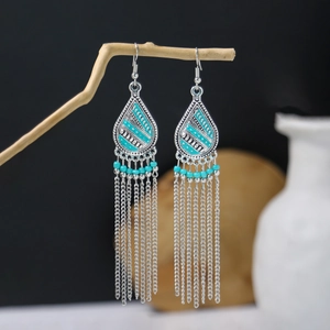 Detailed view of bohemian teardrop earrings with blue beads and long metallic tassels